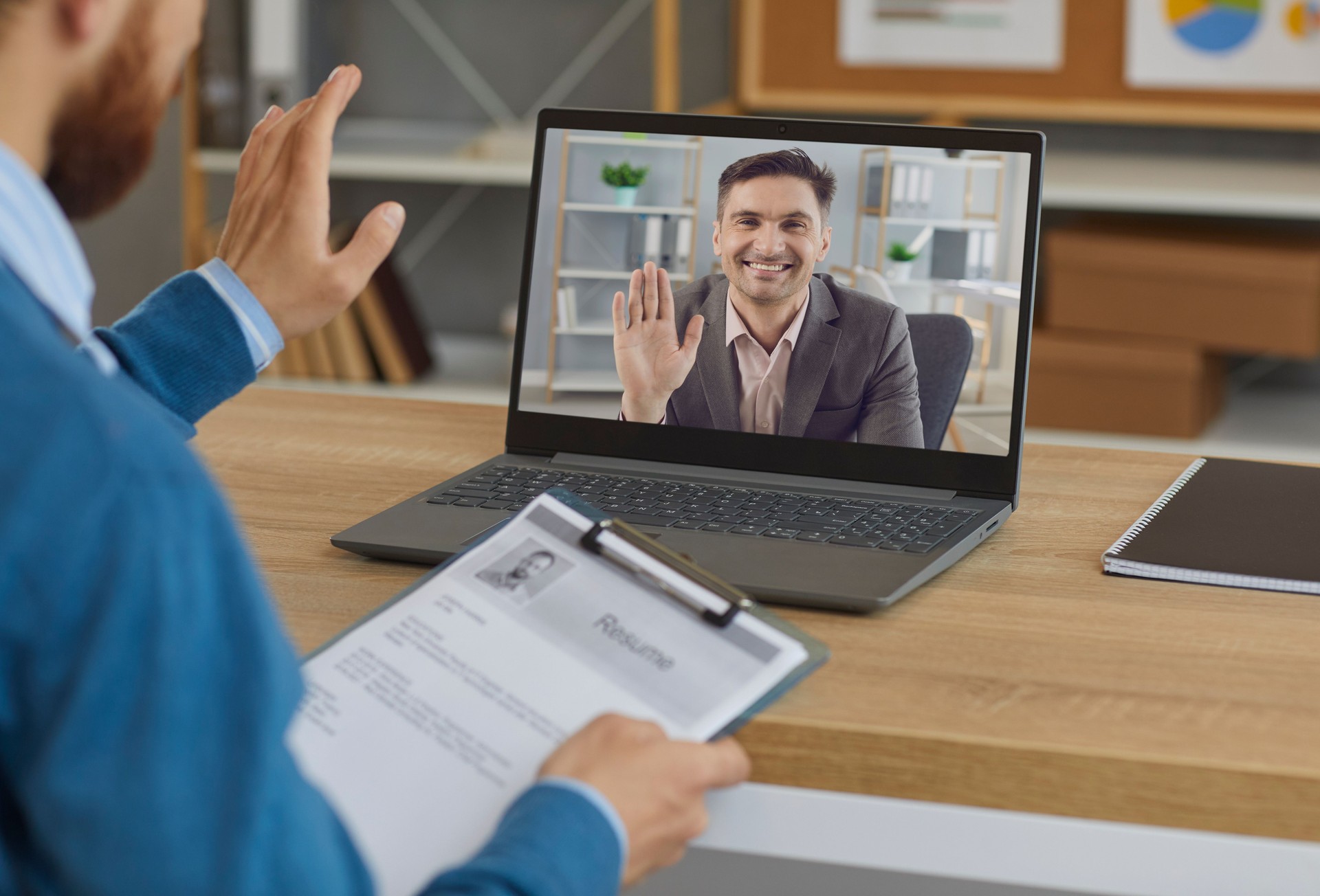 Smiling employer or hiring manager greeting job candidate in virtual job interview